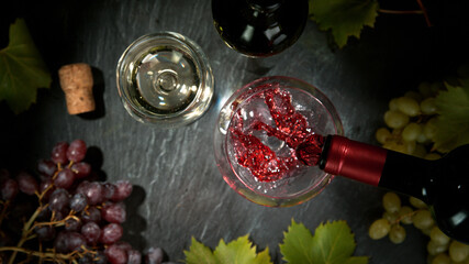 Pouring red wine, black stone background. Top view.