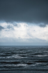 Dramatic dark blue seascape with silver shining waves during storm