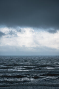 Dramatic dark blue seascape with silver shining waves during storm © Loes Kieboom