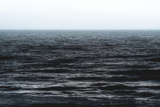 Texture of the cark blue silver shining ocean during storm in Spain