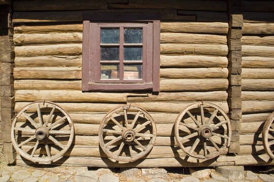 Wooden wheels in front of wooden wall in village