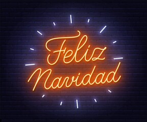 Feliz Navidad neon text. Greeting card on brick wall background.