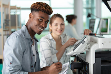 black worker is printing a file at the office