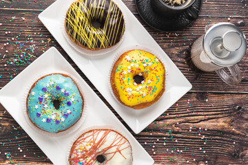 Delicious donuts decorated with different decorations on wooden table
