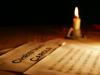 Christmas carols music song sheet with candle