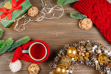 Christmas frame made of Christmas decor, tea mugs, gift box on a wooden table, a place for text