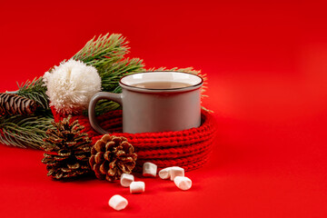 Obraz na płótnie Canvas Christmas card with a mug of tea and New Year's decor on a red background, a place for text