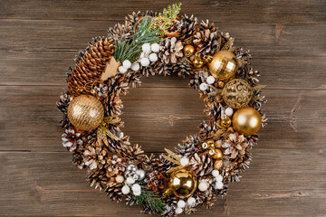 Christmas wreath with festive decor and Christmas tree toys on a wooden background
