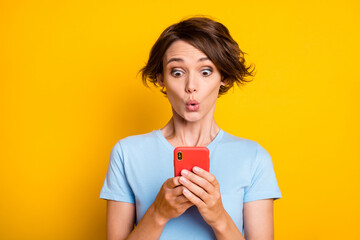Photo of young woman amazed surprised news rumor look cellphone chat type browse isolated over...