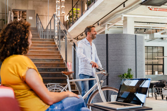 Smiling businessman with bicycle in office