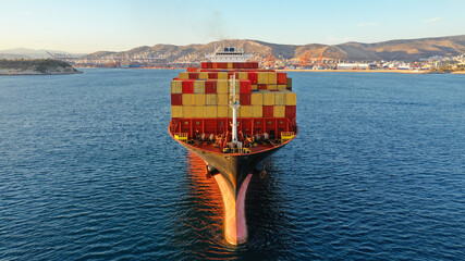 Aerial drone photo of bow from huge container tanker ship cruising deep blue sea near logistics...