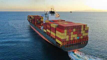 Aerial drone photo of huge container tanker ship carrying truck size colourful containers near...
