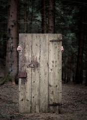 Playing with an old door in the forest
