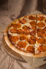 Delicious, aromatic, hot pepperoni pizza on brown background