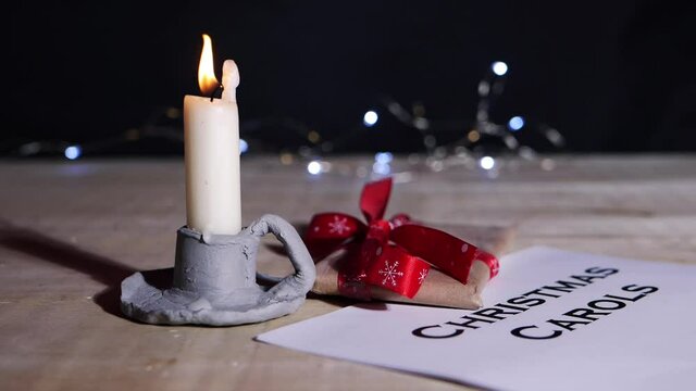 Christmas carol song sheet with candle and gift