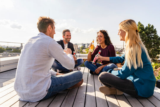 Happy Colleagues Toasting Drinks On Rooftop