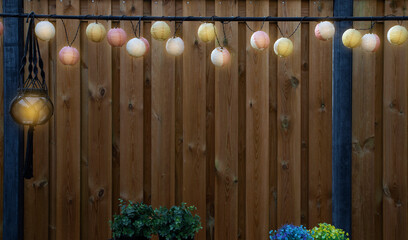 Glowing lanterns lampion lights with delicate design hanging wooden fence,decorative stylish design...