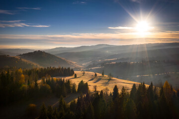 The first rays of the rising sun over the autumnal Tatra Mountains. The pass over Lapszanka. Poland