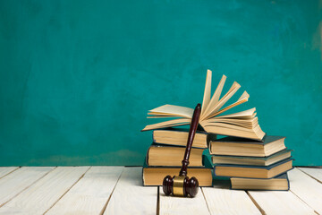 Legal Law and Justice concept - Open law book with a wooden judges gavel on table in a courtroom or...