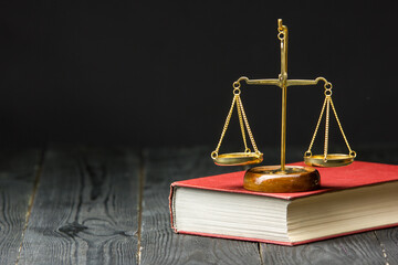 Legal Law and Justice concept - Open law book with a wooden judges gavel on table in a courtroom or law enforcement office. Copy space for text. - 469259322