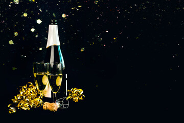 Happy New Year. Champagne bottle with two glasses,golden streamers and sparkling Glitter with space for text. New Years Eve celebration concept background