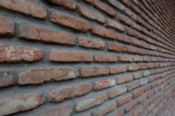 Red background of old vintage brick wall texture. Close up view of old stone brick wall with medieval masonry. perspective photography