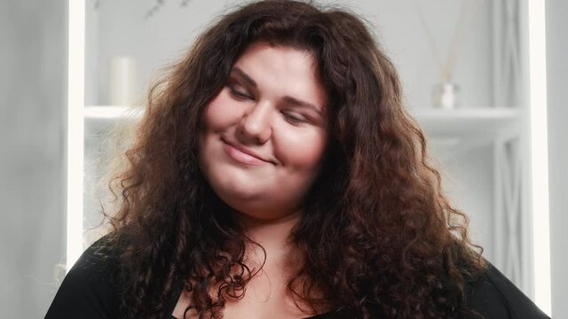 Overweight woman face. Facial care. Body positive. Smiling satisfied attractive plus size obese beauty model with natural makeup flawless pure smooth skin in bathroom.