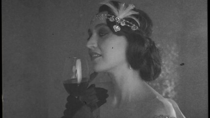 Video with noise, black white color style. Happy young beautiful retro woman glass wine in hand relax enjoy beauty party holiday in style 20s. Portrait brunette vintage headband hairstyle finger wave 