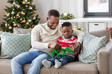 family, winter holidays and people concept - happy smiling african american father and baby son...