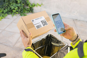 Delivery man scanning QR code through mobile phone