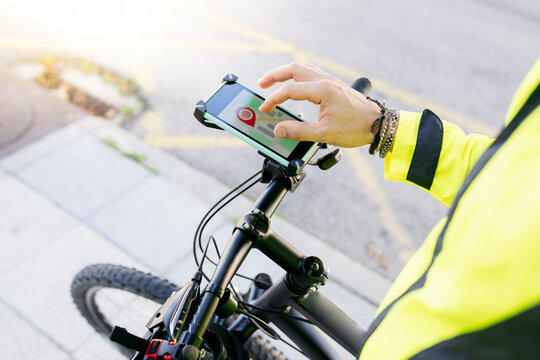 Delivery man searching location on city map through smart phone