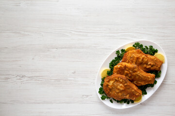 Homemade Fried Pork Chops on a White Plate, top view. Flat lay, overhead, from above. Space for text.