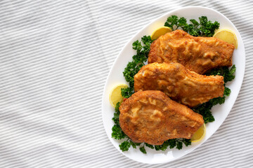 Homemade Fried Pork Chops on a White Plate, top view. Flat lay, overhead, from above. Space for text.