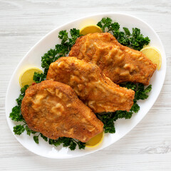 Homemade Fried Pork Chops on a White Plate, top view. Flat lay, overhead, from above.