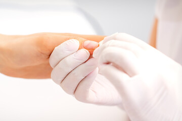 Naklejka premium Manicure master wiping the moisturizer from the end of female fingers in beauty salon