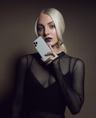 A young beautiful woman with blond hair holds a modern smartphone in her palm. Mobile phone advertising.Advertising concept.