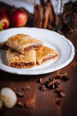 Turkish or Bosnian dessert called Baklava with pistachio served with traditional Turkish or Bosnian coffee set on a wooden board in moody atmosphere