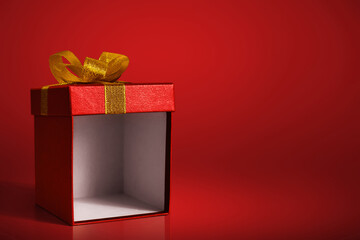 Open gift box on red background