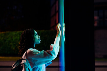 Woman with backpack touching kiosk screen