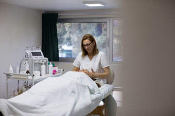 Beautician massaging face of woman in salon