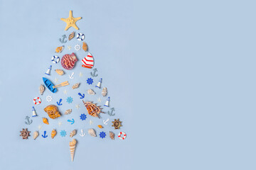 Christmas tree made of decorative ocean items: seashells, starfish, vessels, lighthouses, lifebuoys, steering wheels, anchors. New year holidays at sea, travel, cruise, voyage concept. Copy space