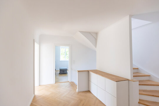 Clean unfurnished home interior with white walls and parquet floor