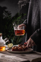 Young woman drinking hot tea with cranberry pie
