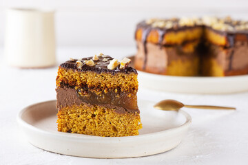 Pumpkin pie with chocolate and nuts on a plate. Sugar, gluten and lactose free, vegan.