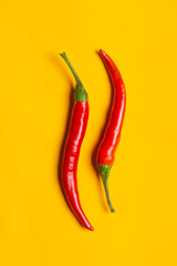 Chilli peppers on yellow background with copy space