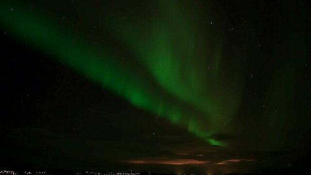 Aurora Borealis Over The City On The Coast - Polar Lights In The Night Starry Sky  - low angle shot