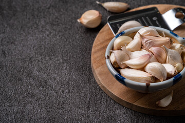 Fresh garlic cloves on black table background.