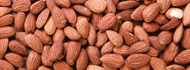Top view of peeled Almonds for cover banner for social media or other background or wallpaper. Healthy foods concept.