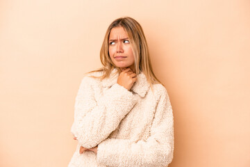 Young caucasian woman isolated on beige background suffers pain in throat due a virus or infection.