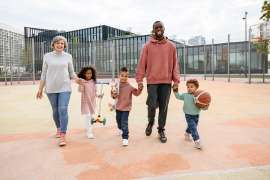 Family Holding Each Other's Hands At Sports Field